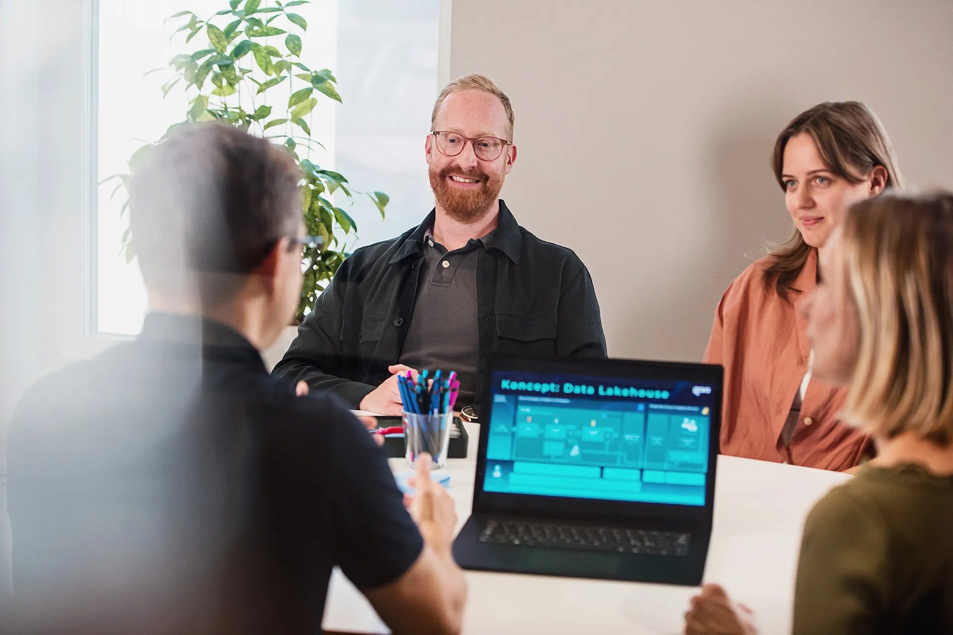 Teamet diskuterar en Data Lakehouse-lösning framför en laptop
