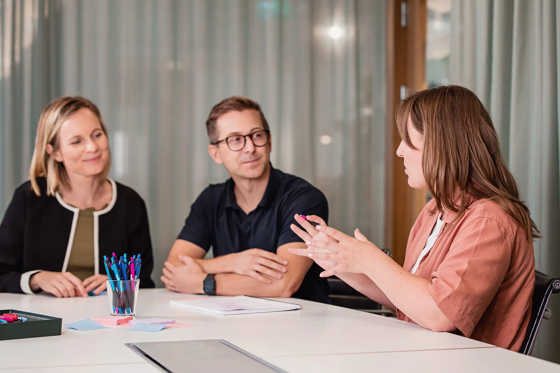 Tre kollegor fokuserar på en laptop och analyserar kod
